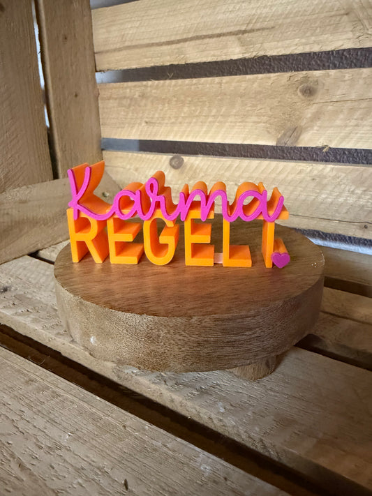 Schriftzug zweifarbig „Karma regelt"